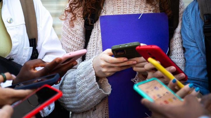 Grupo de adolescentes mexendo no celular
