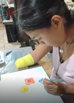 Nayarit dibujando con un pincel con la mano izquierda.