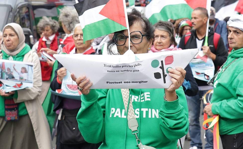 Mujer en una manifestación en París con un barco de papel