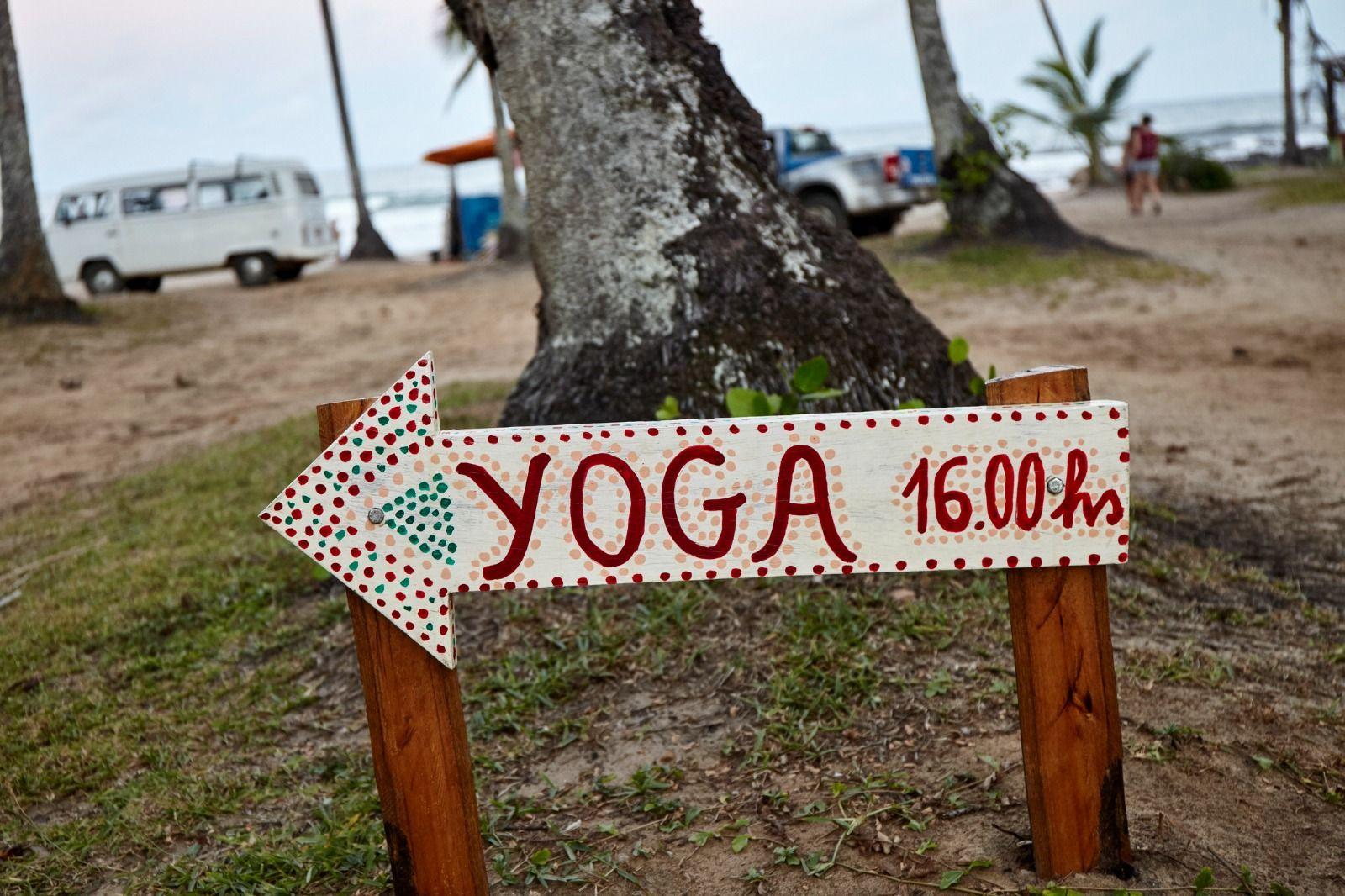 Placa anunciando aula de ioga na praia de Itacar&eacute;, na Bahia