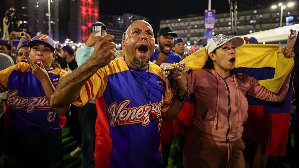 Aficionados celebran el triunfo de Venezuela.