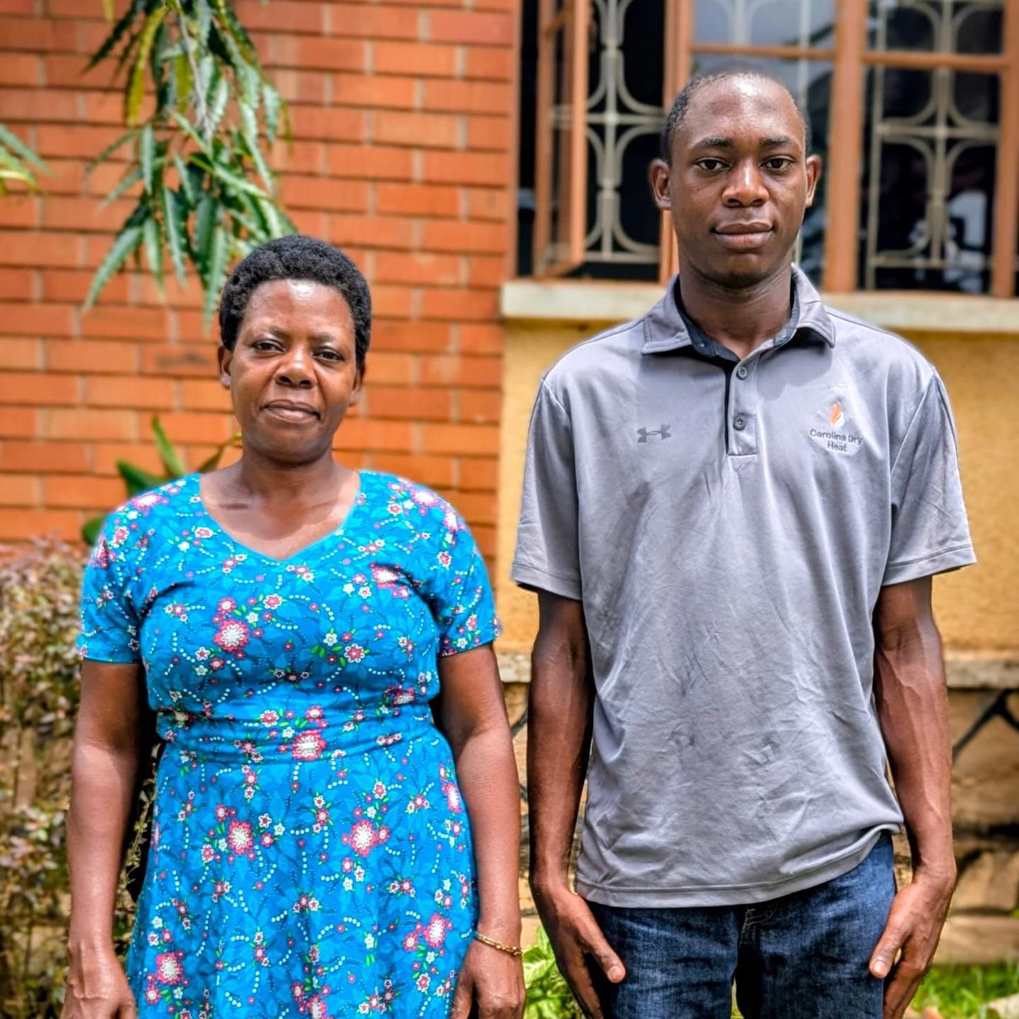 تقف ماريا وجوزيف جنباً إلى جنب في الخارج تحت أشعة الشمس. ترتدي ماريا، على اليسار، فستاناً أزرق زاهياً بنقوش زهرية، بينما يرتدي جوزيف، وهو أطول من والدته، قميصاً رمادياً وبنطال جينز. يبتسم الاثنان بهدوء.