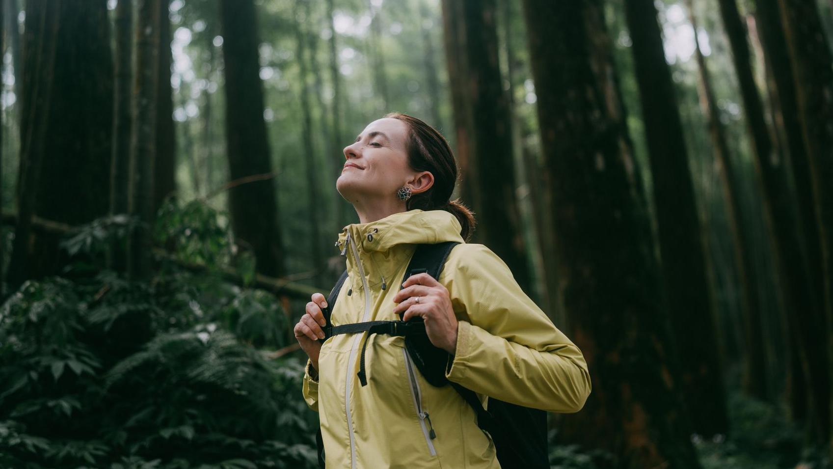 Mujer contemplando en el bosque.
