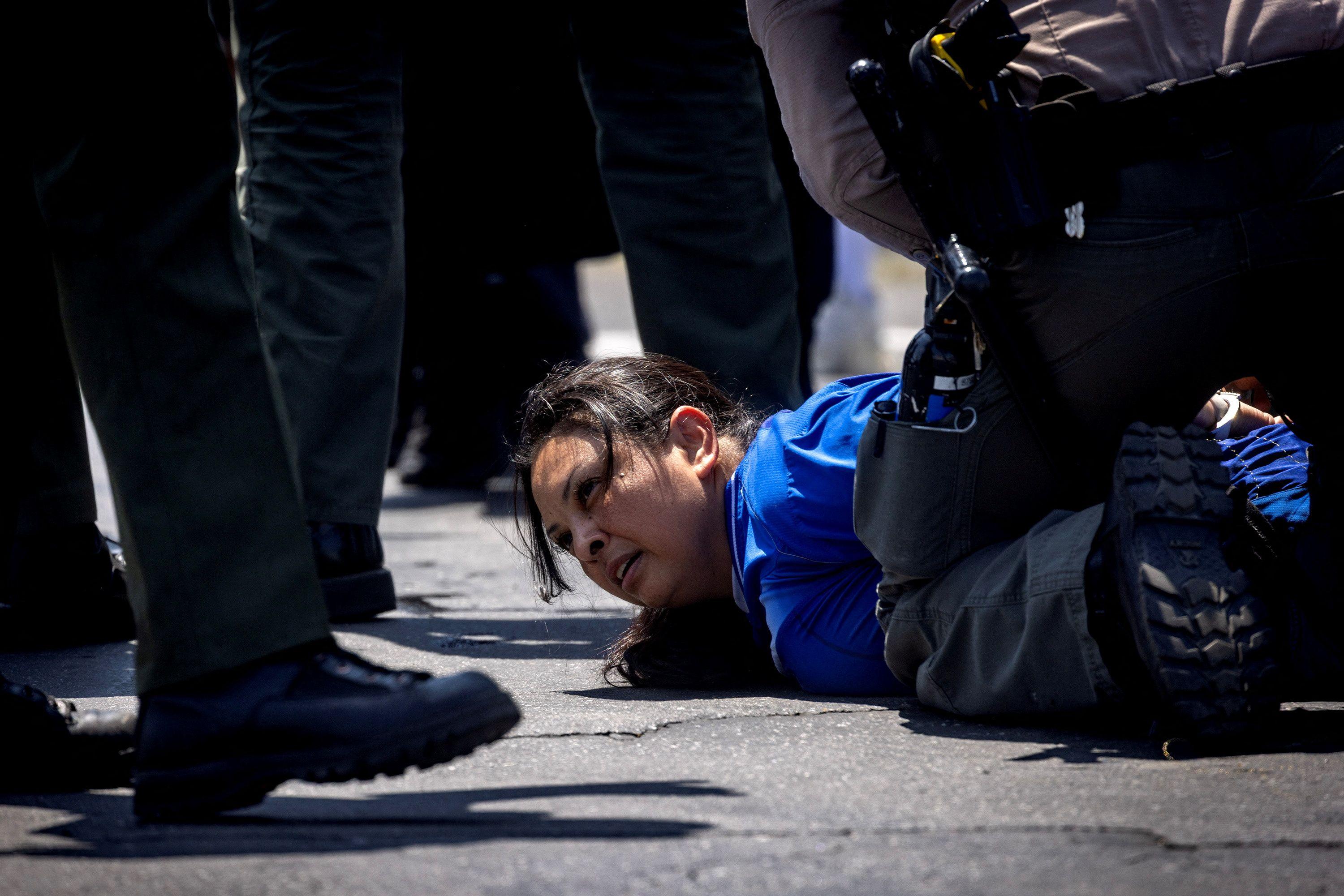 Oficiais do condado de Los Angeles detêm uma mulher durante confronto entre manifestantes e policiais, após várias detenções pelo Serviço de Imigração e Alfândega (ICE), na cidade de Paramount, no condado de Los Angeles, Califórnia