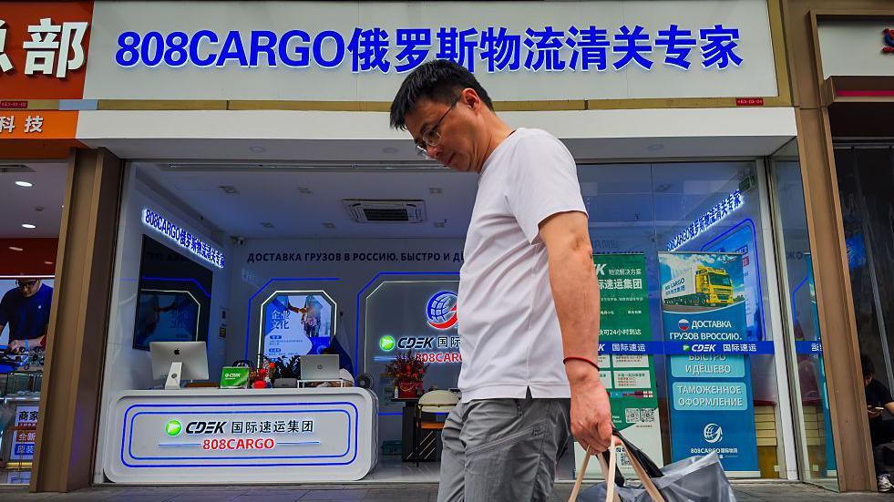 一個男子走過一家店舖