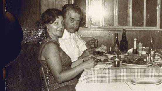 Uma imagem em preto e branco de um homem e uma mulher comendo