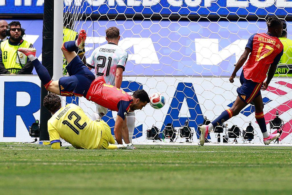 El centrocampista español Mikel Merino remata de cabeza para marcar un gol ante el portero de Bélgica, Senne Lammens.