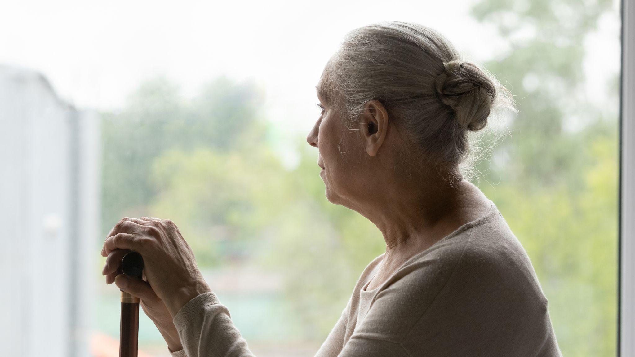 設計圖片：一位感覺氣餒的老太太望向窗外