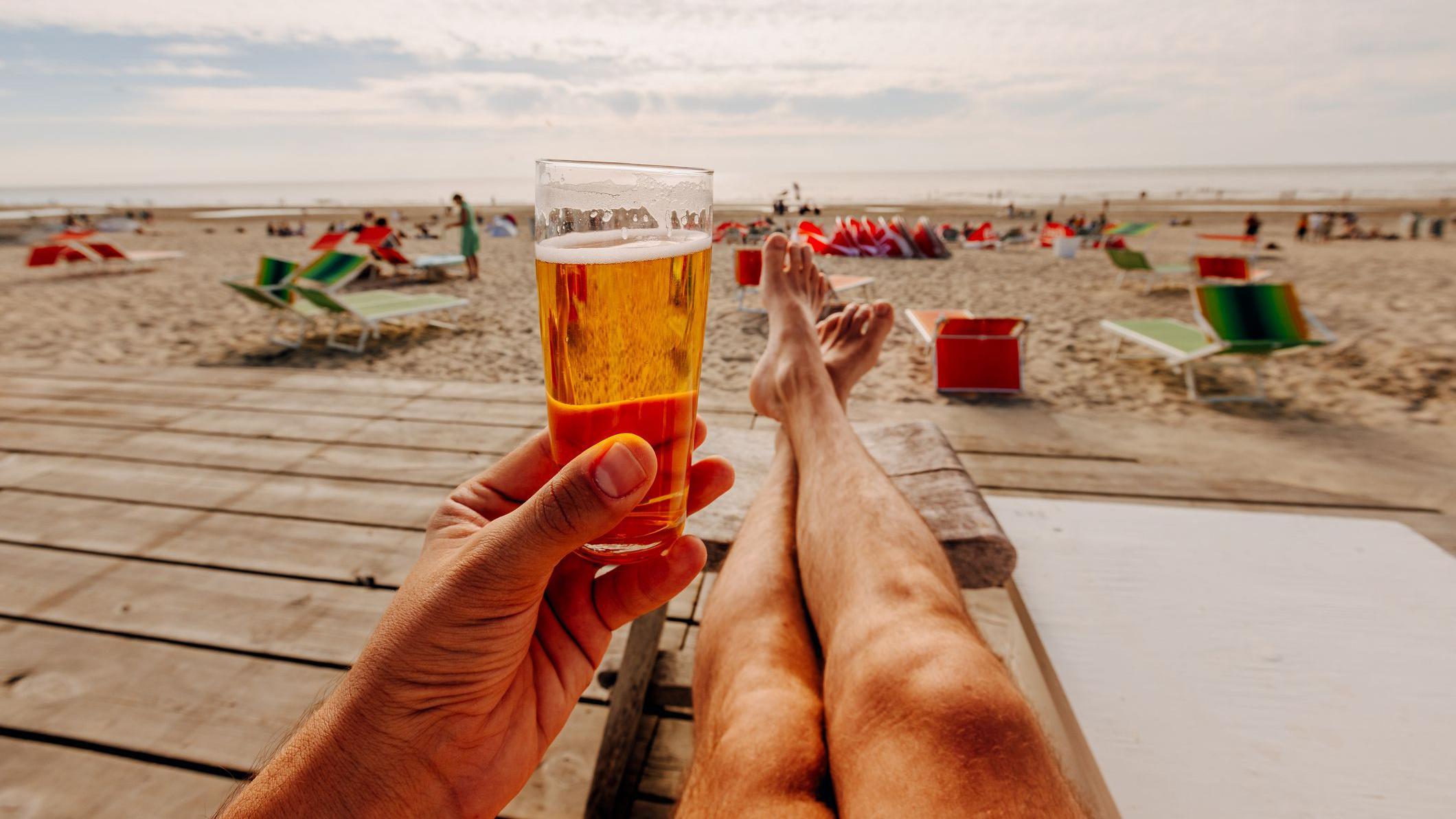 Hombre en la playa bebiendo cerveza