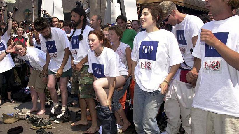 Manifestantes anti-G8 se quitan la ropa durante una protesta frente a la tienda Gap en Calgary, Alberta, Canadá, antes del inicio de la Cumbre del G8 de 2002.