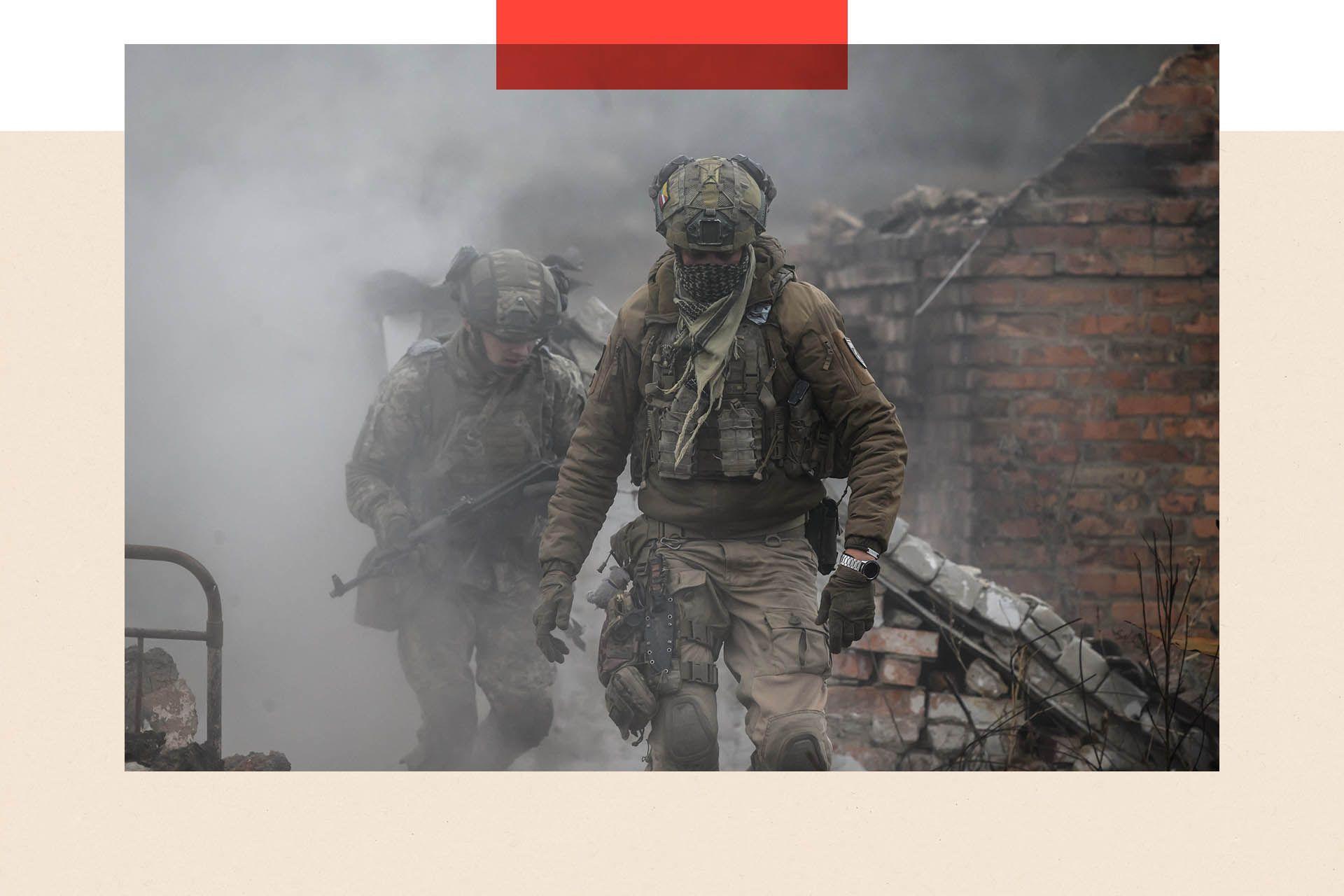 Šta bi moglo da zaustavi Putinovo ratovanje u Ukrajini 4 Dva vojnika u punoj opremi, iza njih su ruševine