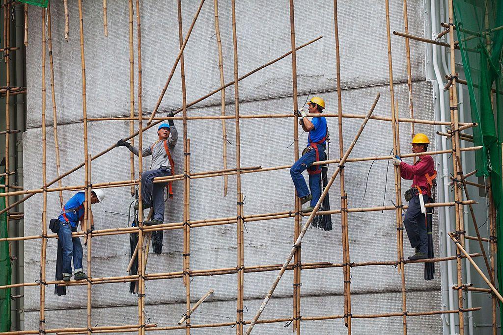 Operários em andaimes de bambu
