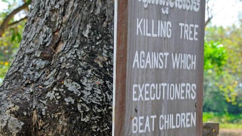 لافتة معلقة على جذع شجرة