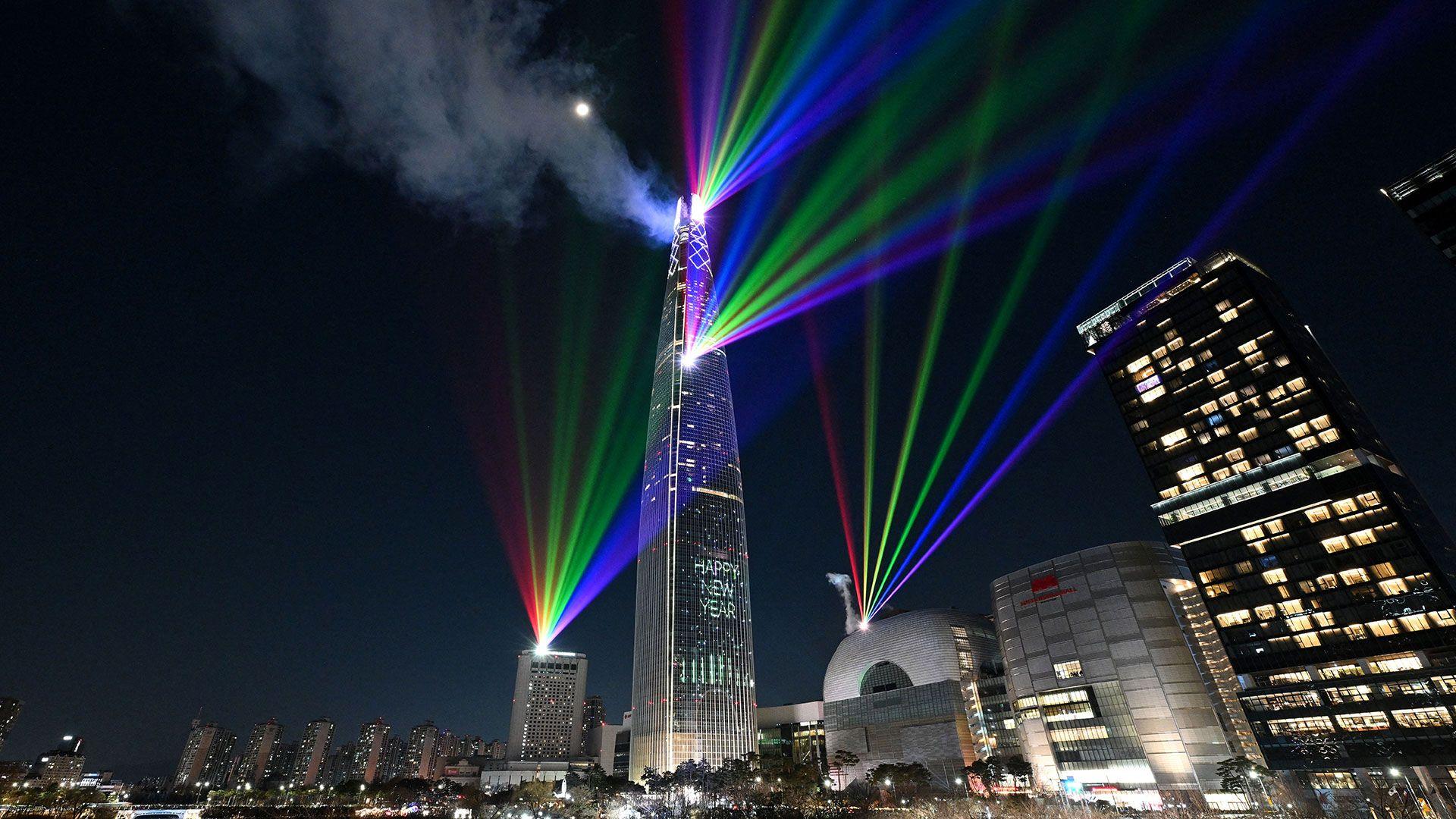 Luces láser iluminan el cielo nocturno sobre la Torre Lotte World, el edificio más alto de Corea del Sur, en Seúl.
