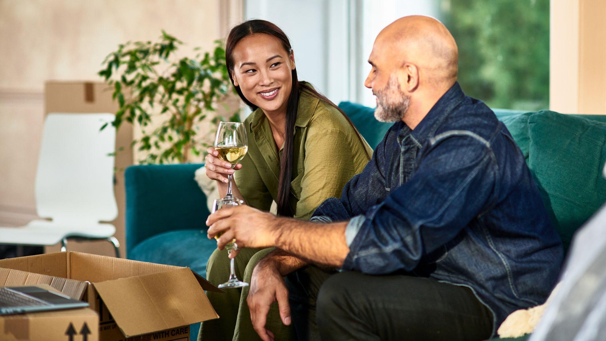 Casal jovem e bem sucedido, brindando com ta&ccedil;as de vinho