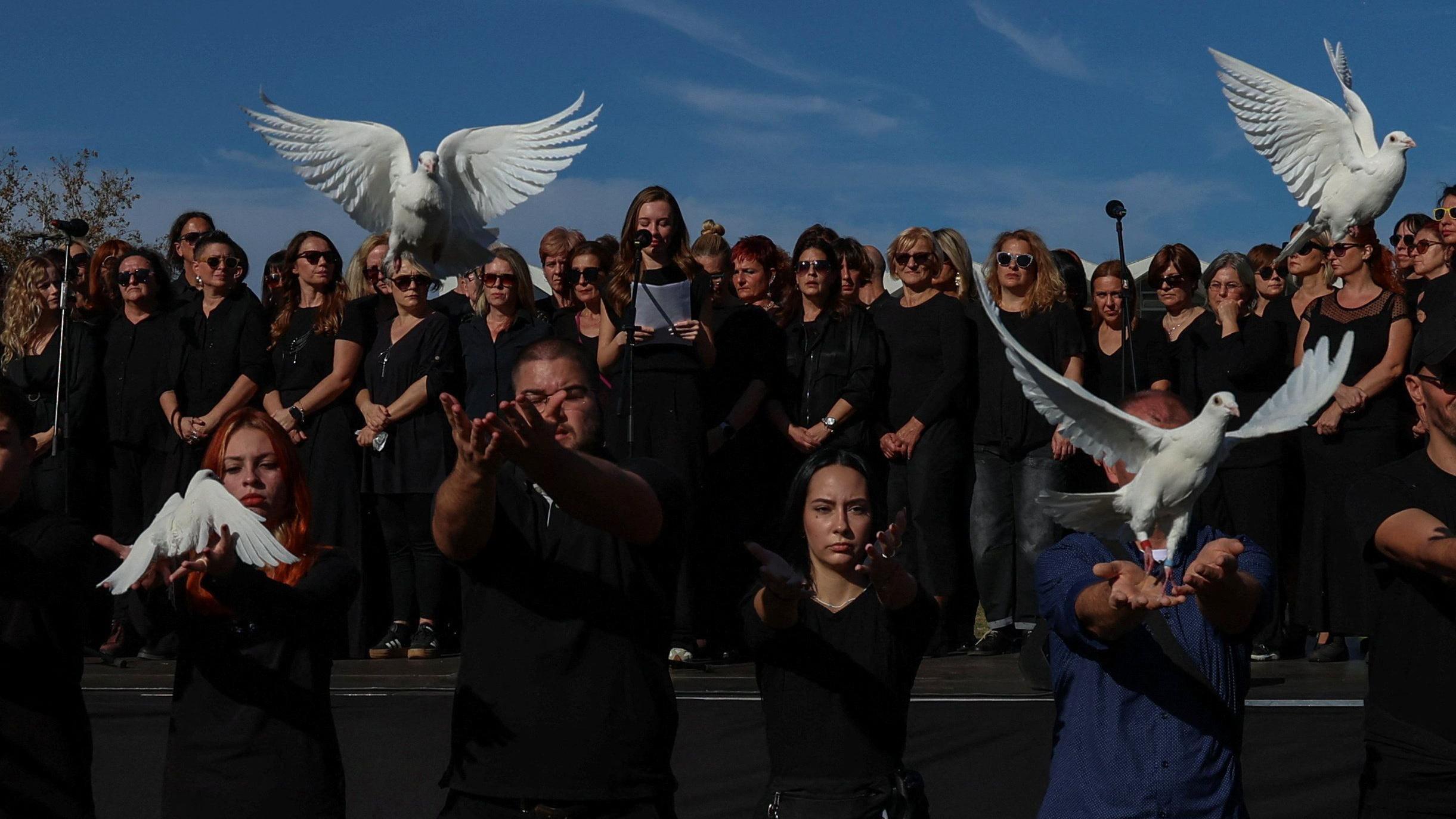 Ljudi obučeni u crnom puštaju golubove