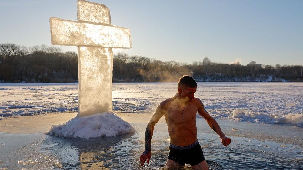 Muškarac uranja u ledenu vodu tokom proslave pravoslavnog hrišćanskog praznika Bogojavljanja u jeku rusko-ukrajinskog rata u Donjecku