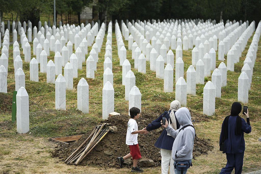 Cuatro personas recorren el memorial que recuerda en Potocari a las víctimas de Srebrenica.