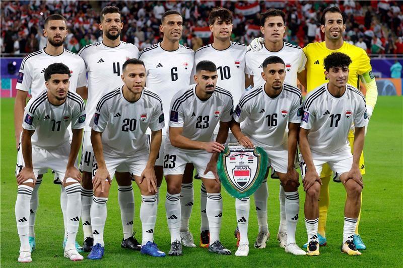 مباراة العراق والسعودية بصافرة أردنية، من يبلغ نهائيات مونديال 2026؟ 4 المنتخب العراقي لكرة القدم بلباسه الأبيض يحمل درعاً ويقف على أرض الملعب مستعداً لالتقاط صورة.