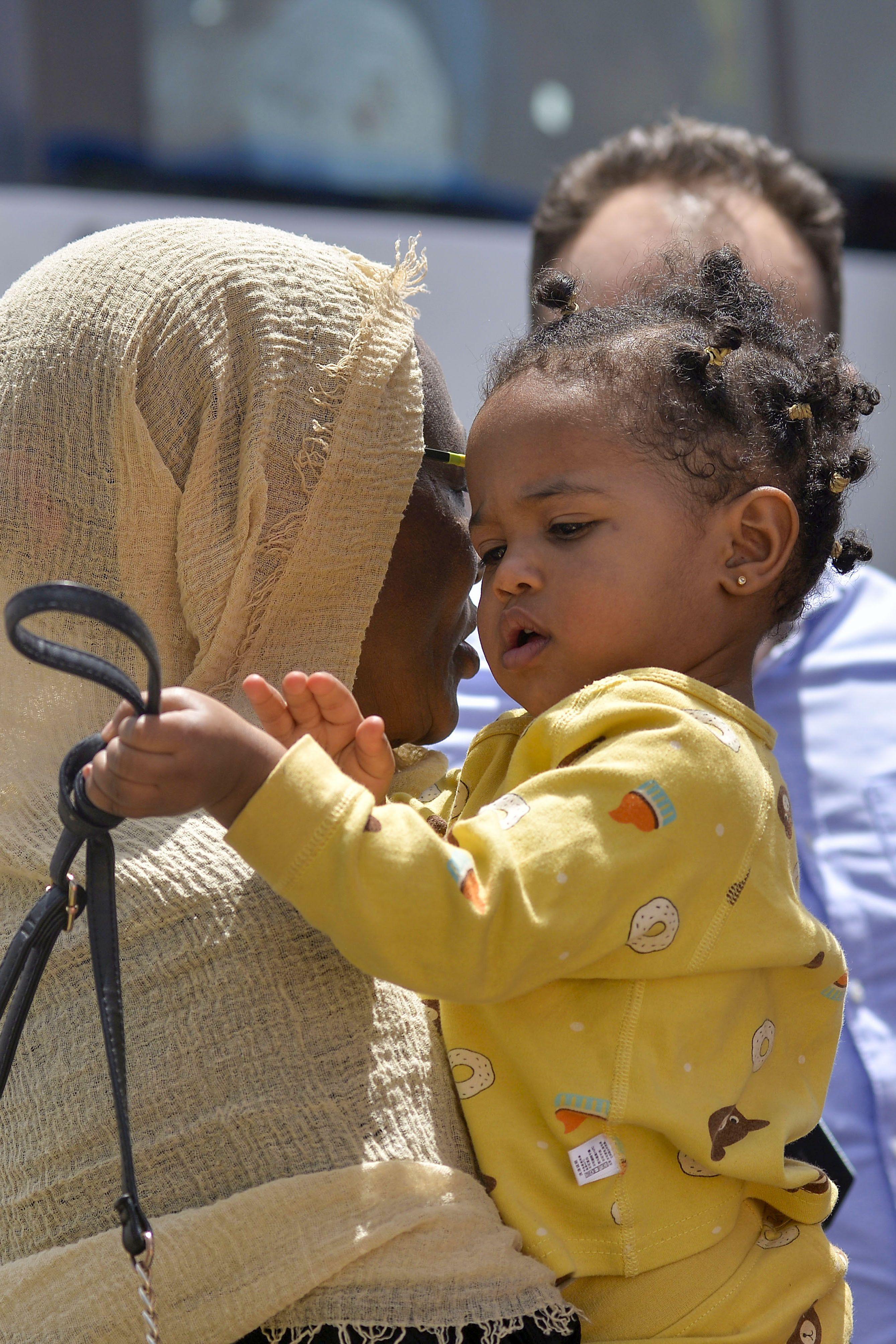 صورة لأم سودانية تحمل طفلتها