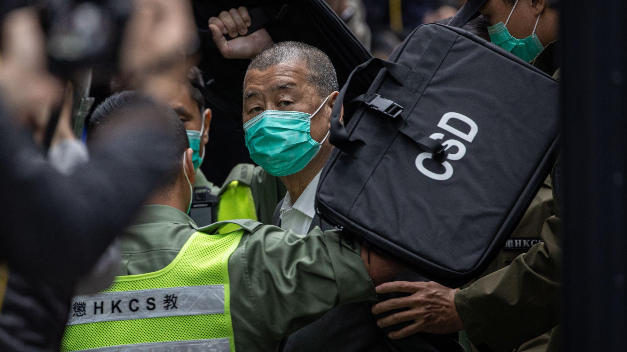 戴上綠色醫用口罩的黎智英在香港終審法院被懲教署獄警押下車（9/2/2021）
