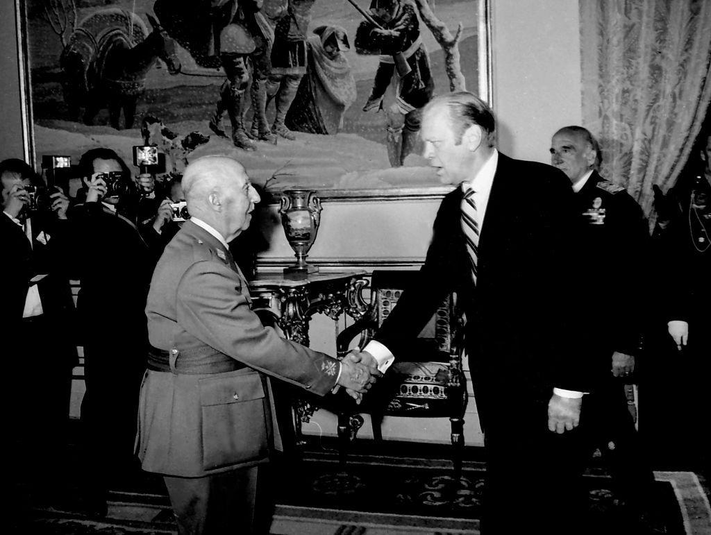 El general Franco, vestido de uniforme, estrecha la mano del presidente Gerald R. Ford, de traje oscuro y corbata de rayas, en una visita del segundo a Madrid en 1973. 