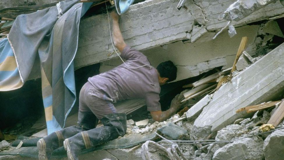 Un hombre busca entre los escombros tras el terremoto de 1985
