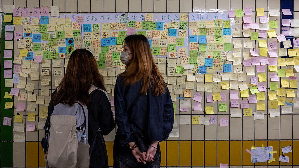 2025年12月1日，在香港大埔宏福苑附近的一條行人隧道牆上，可以看到人們為11月26日致命火災的遇難者留下的手寫悼念卡片。
