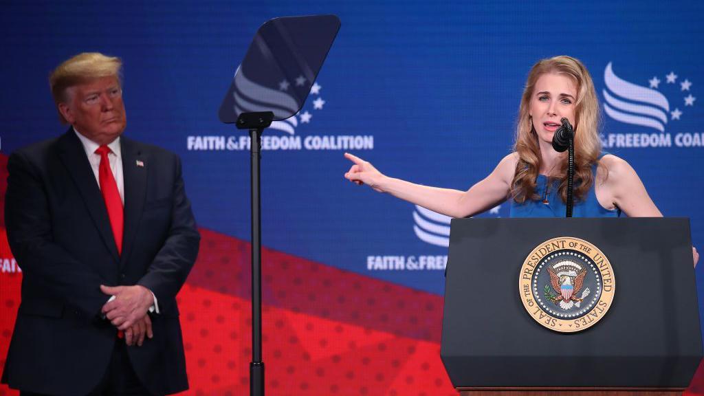Natalie Harp fala apontando para o presidente Donald Trump, durante confer&ecirc;ncia realizada em Washington em 2019