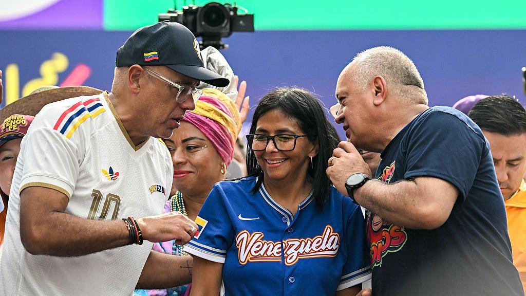 Jorge Rodr&iacute;guez conversa com Diosdado Cabello, com Delcy Rodr&iacute;guez entre eles. Nenhum deles est&aacute; vestido de vermelho