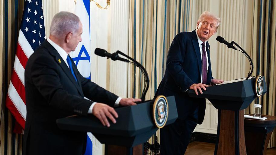 Benjamin Netanyahu y Donald Trump hablan el uno con el otro desde dos atriles en una rueda de prensa en la Casa Blanca. 