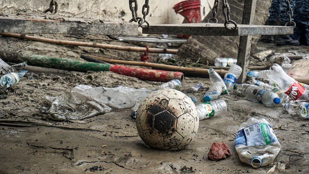Un balón de fútbol chamuscado se ve entre los escombros del incidente.