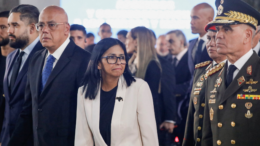 Delcy Rodríguez, con chaqueta blanca, flanqueada por altos dirigentes de la Venezuela chavista.  