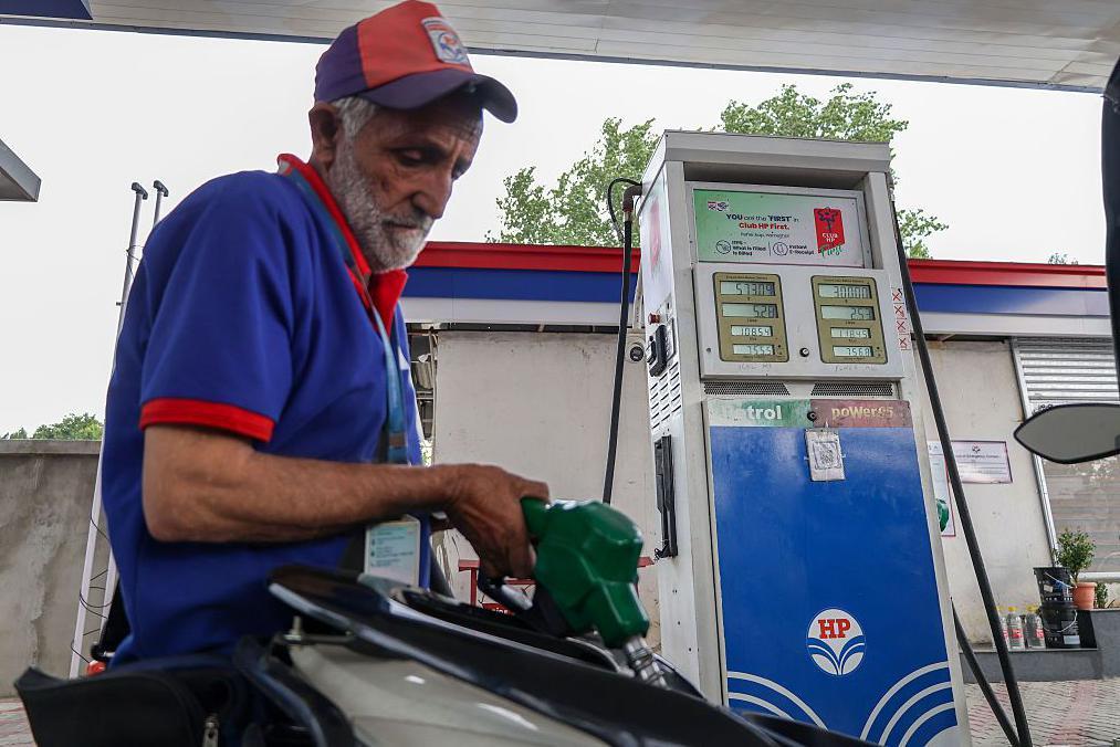Un empleado llena el tanque de una moto mientras se exhiben los precios del combustible, recién aumentados, en una estación de servicio de Hindustan Petroleum en Srinagar, Jammu y Cachemira, el 25 de mayo de 2026.