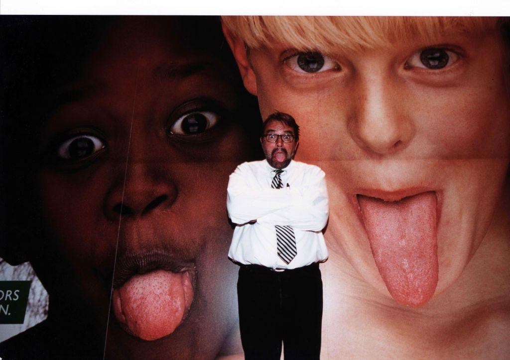 El fotógrafo italiano Oliviero Toscani posa delante de una foto suya para la campaña publicitaria de Benetton. Roma.