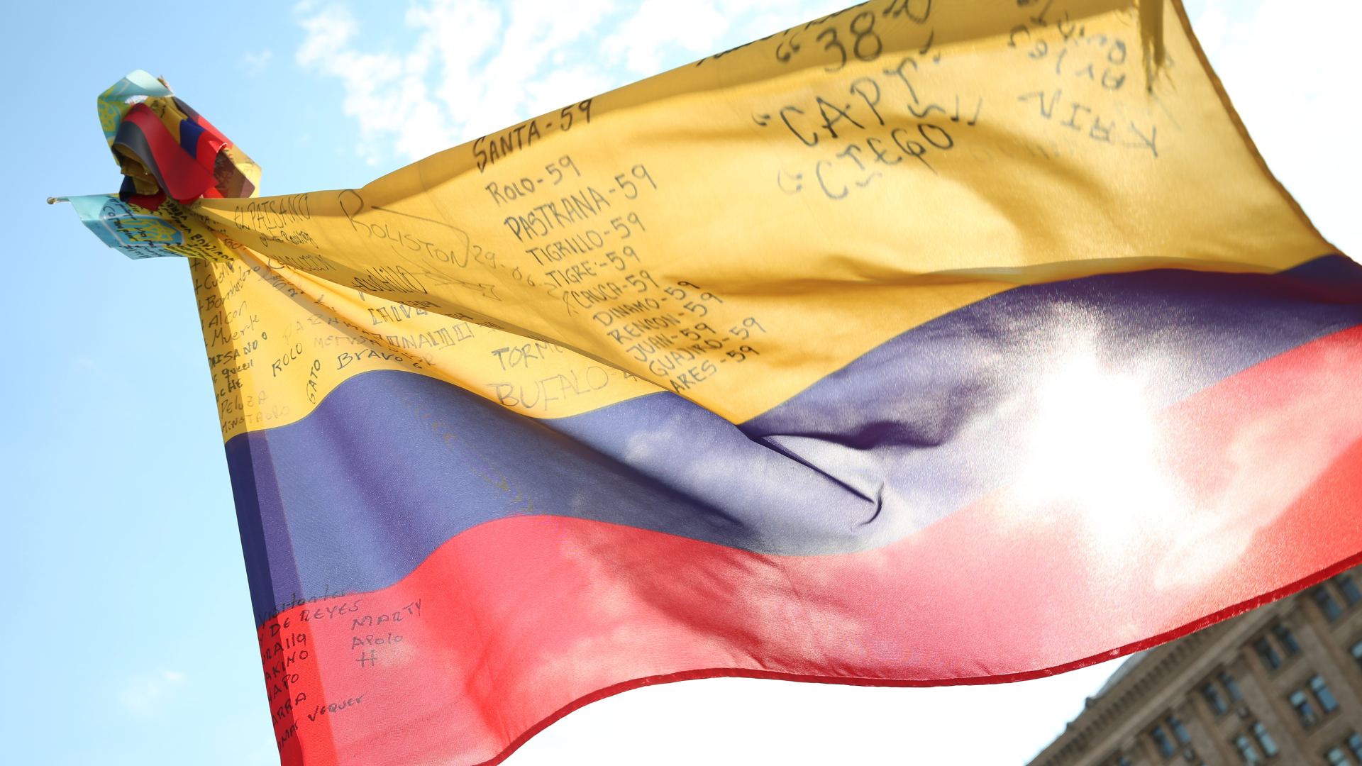 Una bandera colombiana con los nombres de soldados colombianos caídos en combate en Ucrania