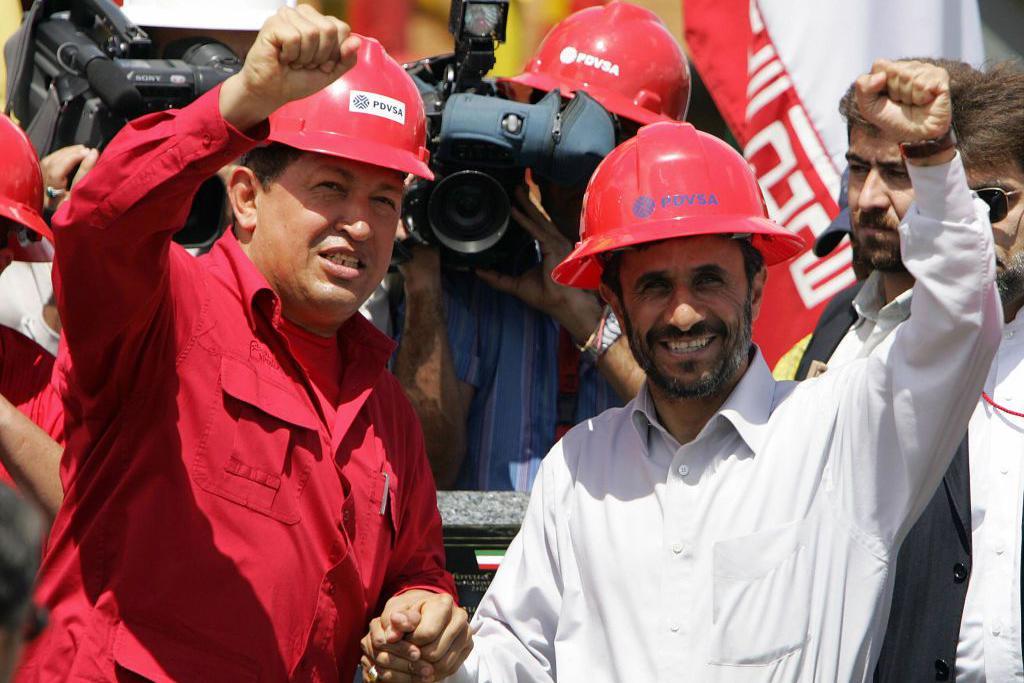 هوغو تشافيز ومحمود أحمدي نجاد يرفعان قبضتيهما في تحية خلال زيارة إلى حوض نهر أورينوكو في جنوب شرق فنزويلا لافتتاح بئر نفط جديدة، في 18 سبتمبر/أيلول 2006.