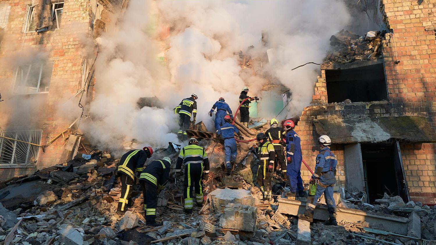 消防員在住宅大樓撲滅火焰，救援人員在俄羅斯彈道飛彈襲擊後於基輔的瓦礫中搜尋受害者