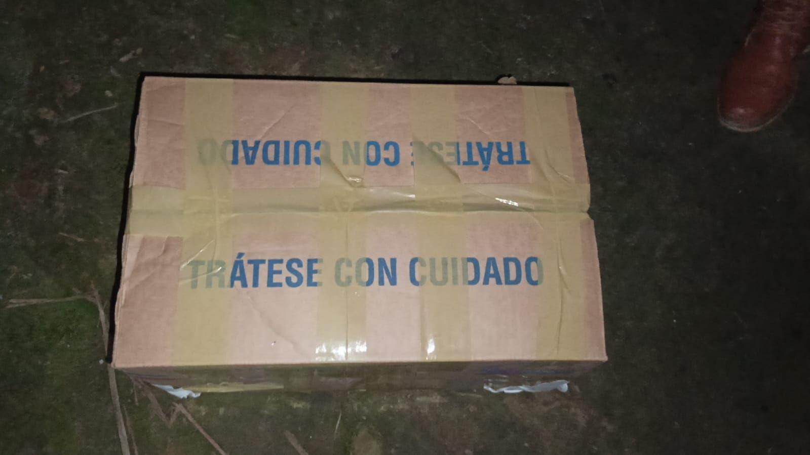 La caja de cartón cerrada con cinta y con un mensaje en azul que dice "Trátese con cuidado".