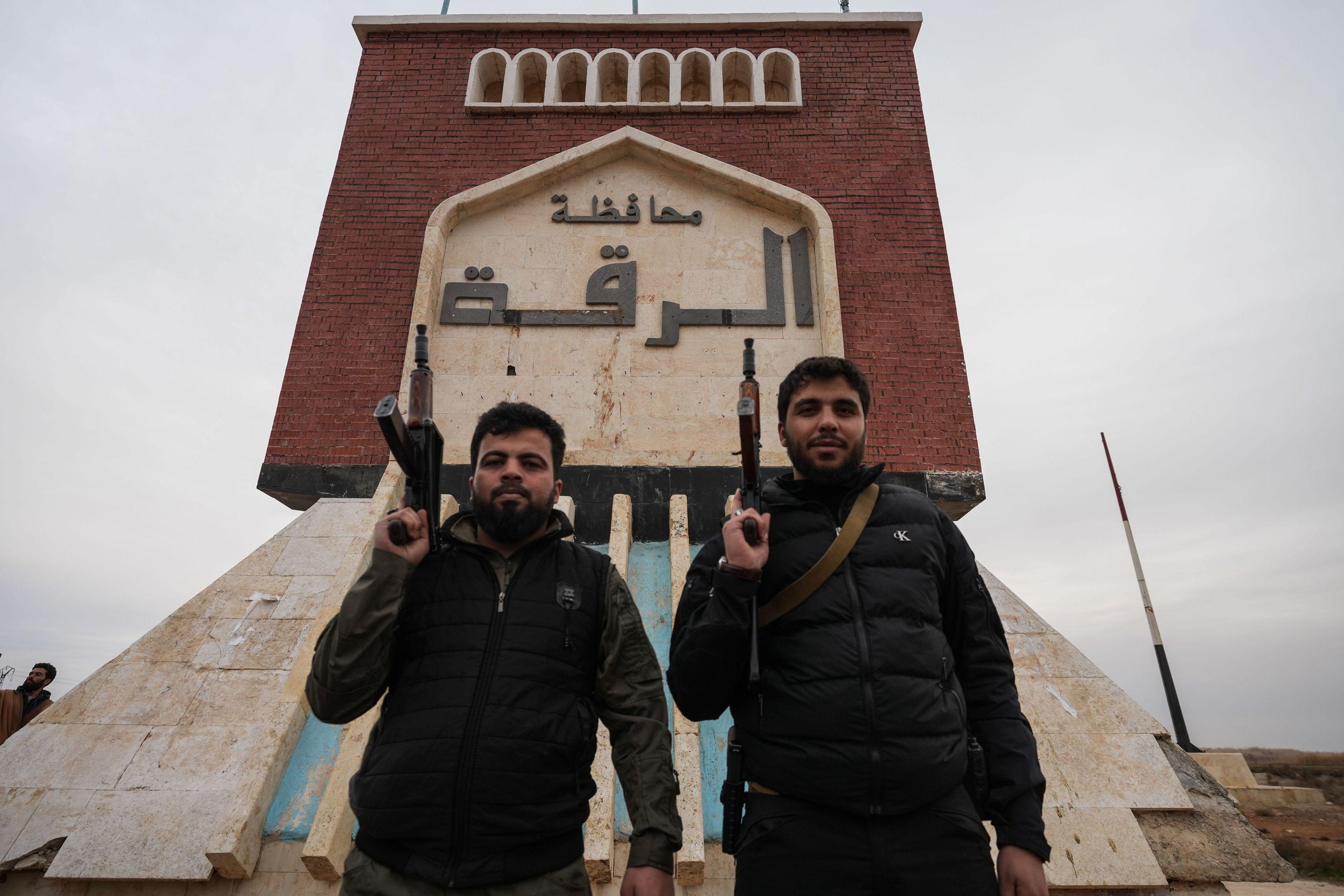 عناصر في الجيش السوري تقف أمام لافتة كُتب عليها "الرقة ترحب بكم" بعد انسحاب قوات سوريا الديمقراطية من قرية في ريف الرقة في 17 يناير/ كانون الثاني 2026