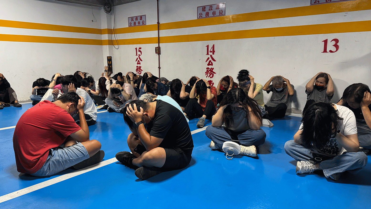 演習中，金門的民眾雙手抱頭坐在地上