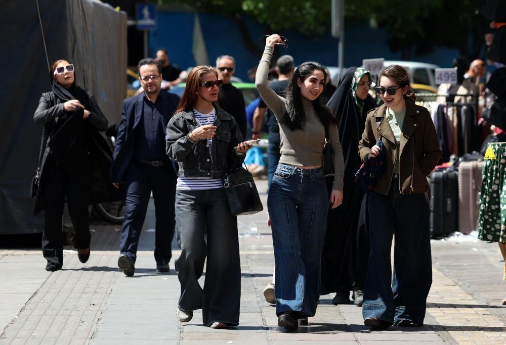Um grupo de mulheres caminhando por uma rua em Teer&atilde;.