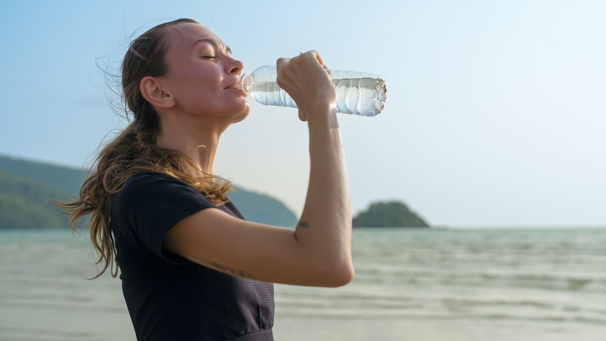 Mujer bebiendo una botella de agua.