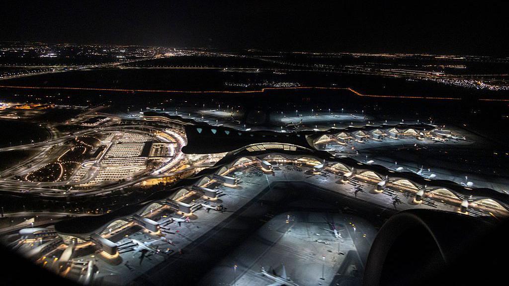 Vista a&eacute;rea noturna da janela de um avi&atilde;o mostra diversas aeronaves estacionadas no Aeroporto Internacional Zayed, em Abu Dhabi, nos Emirados &Aacute;rabes Unidos