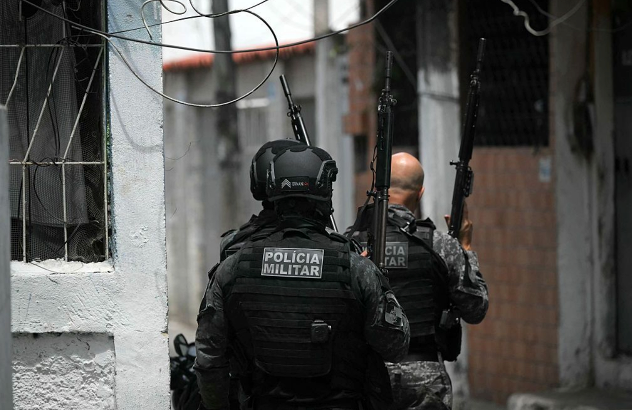 Dois policiais militares uniformizados e armados fazem incursão em favela no Rio de Janeiro 