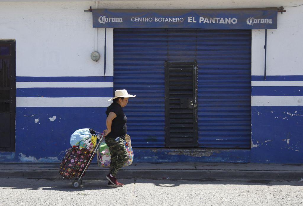 Una mujer pasa por el bar donde un grupo armado asesinó a 12 personas al abrir fuego contra clientes y personal, en Irapuato, estado de Guanajuato, México, el 16 de octubre de 2022. - Doce personas fueron asesinadas en un tiroteo en un bar del centro de México el sábado, según dijeron las autoridades locales, en medio de una creciente violencia de los cárteles que hace de la región una de las más peligrosas del país. (Foto de MARIO ARMAS / AFP) (Foto de MARIO ARMAS/AFP vía Getty Images)