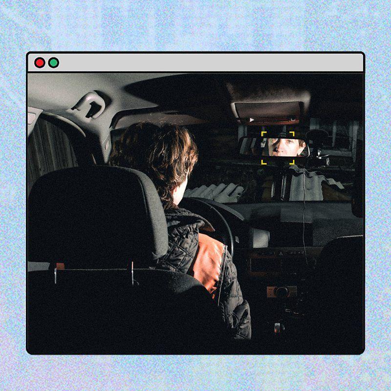 一幅插畫顯示汽車內部場景，從後座視角可見一名駕駛者坐在駕駛座，車內昏暗。擋風玻璃前方與倒後鏡附近出現帶有方框標記的偵測畫面，顯示系統正在鎖定與分析駕駛者的面部或行為。