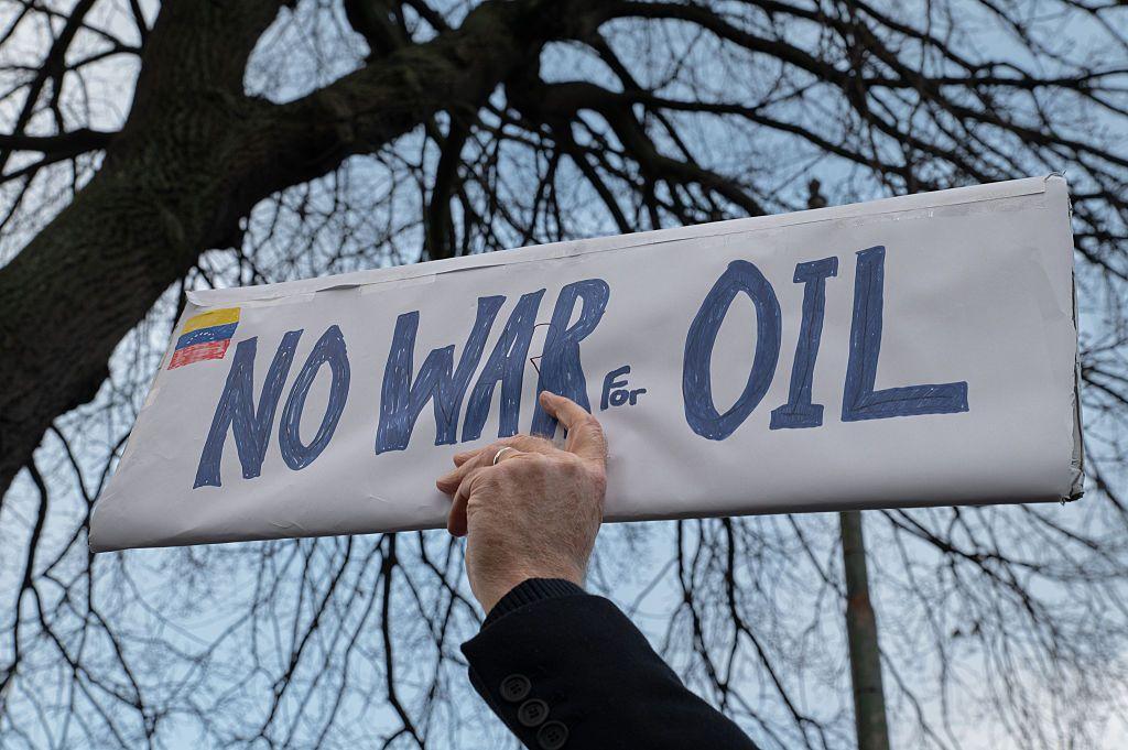 一名男子的手舉著寫有「不為石油而戰」的牌子，站在美國駐都柏林大使館前。