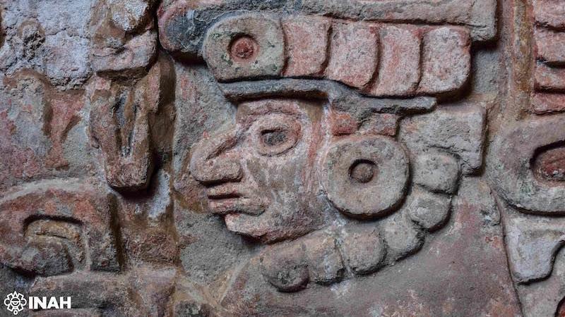 Una cabeza y otras figuras labradas en piedra en la Tumba 10 de Huitzo, Oaxaca