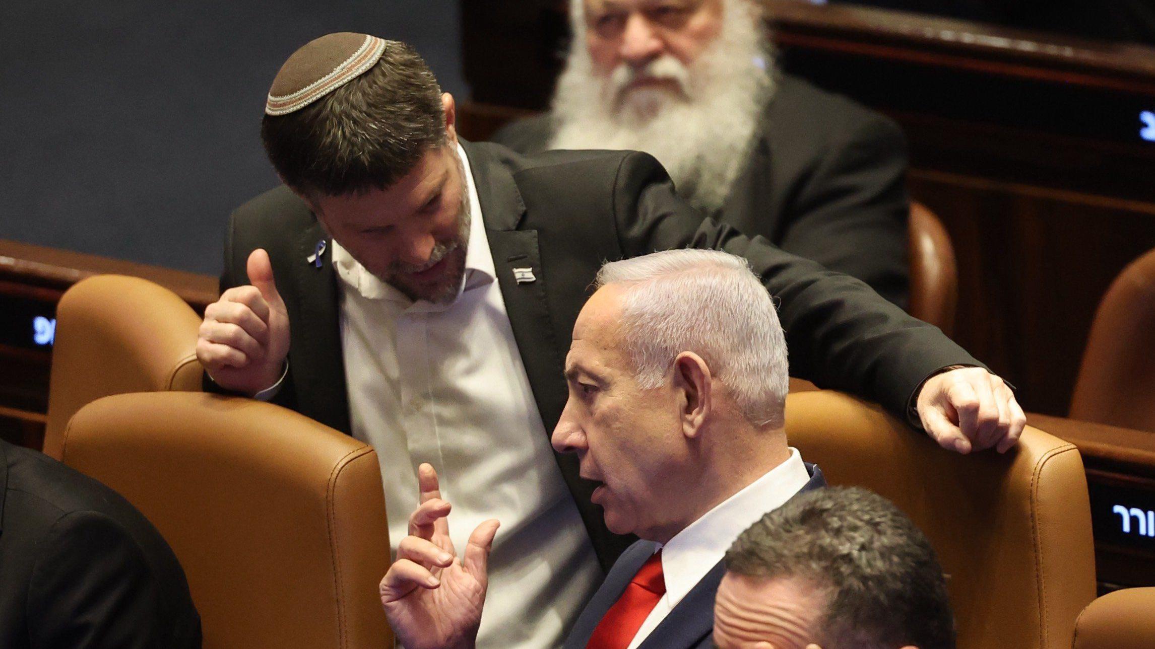 رئيس الوزراء الإسرائيلي بنيامين نتنياهو يتحدث مع وزير المالية الإسرائيلي بتسلئيل سموتريتش خلال جلسة للكنيست للتصويت على مشروع قانون لفرض السيادة الإسرائيلية على الضفة الغربية